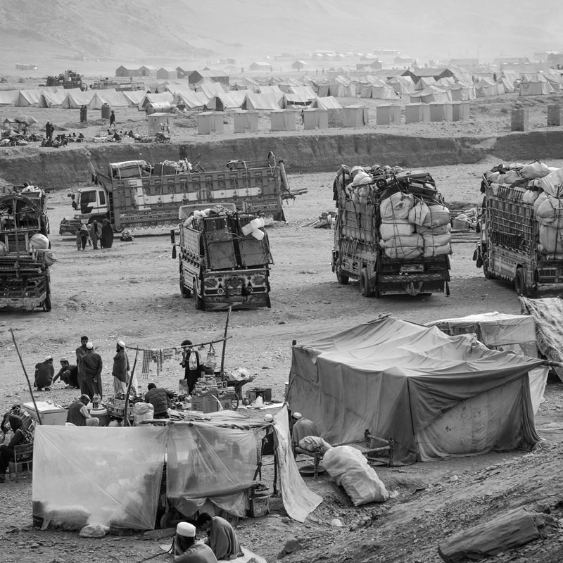 Trucks with belongings of several families are waiting for Afghans to obtain some assistance and define the place they will go to settle. Torkham Reception Center, Nangarhar, 23 November 2023. @DRC, Manon Radosta 