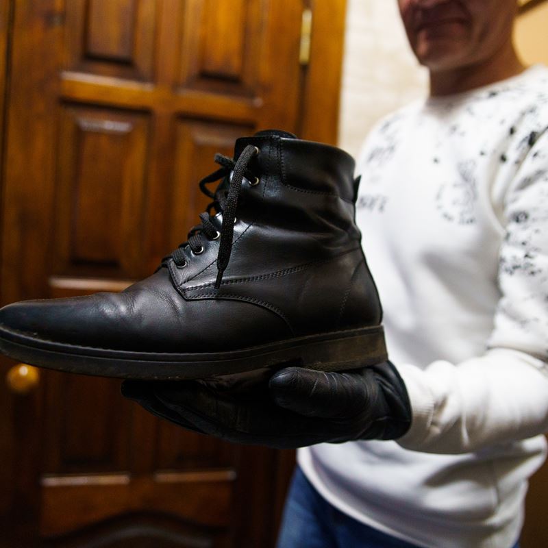 Taras shows a pair of shoes that he crafted for personal use.©DRC Ukraine, Chernihiv, February 2023, Volodymyr Cheppel.  