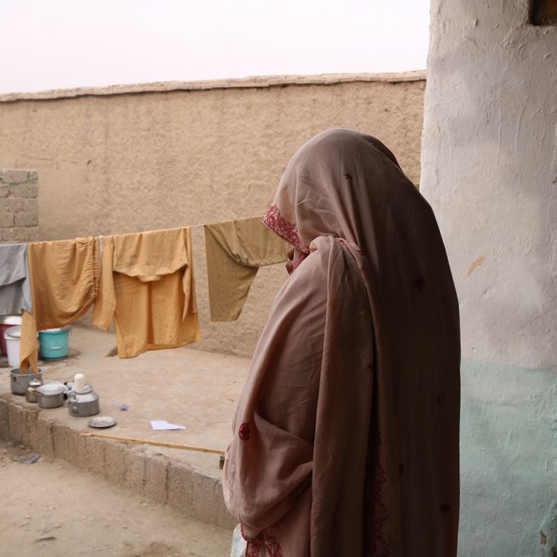 Mariam is telling us her story in the open area of her house in an IDP settlement that she can barely afford. Kuz Shekh Mesri Camp, Jalalabad, Nangarhar. 26 November 2023. @DRC, Manon Radosta 